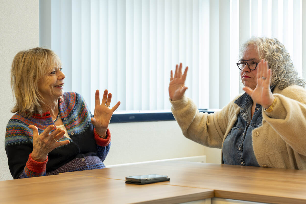 Sarah, een dove tolk Gebarentaal en Corline, een tolk Gebarentaal, gebaren in gesprek naar elkaar