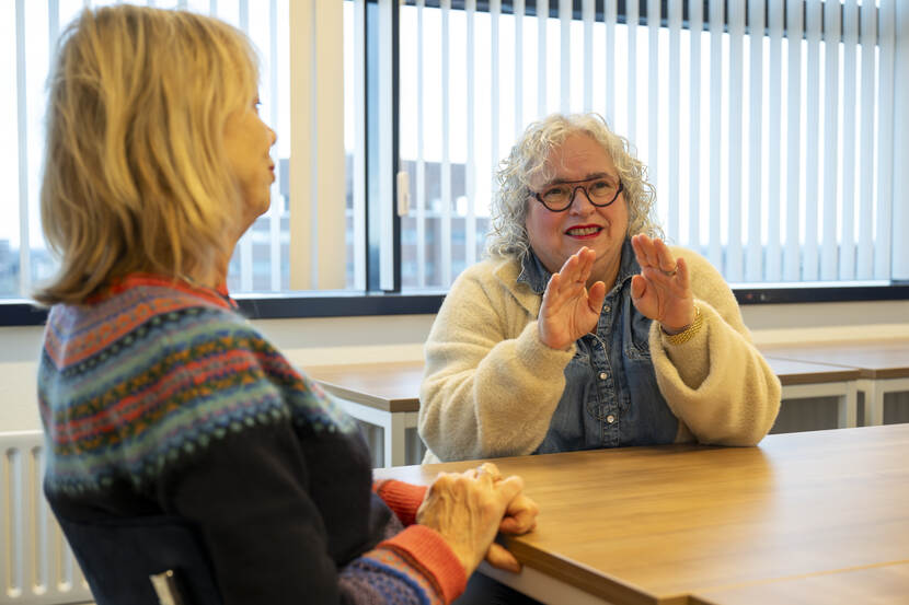 Sarah, een dove tolk Gebarentaal en Corline, een tolk Gebarentaal, gebaren in gesprek naar elkaar