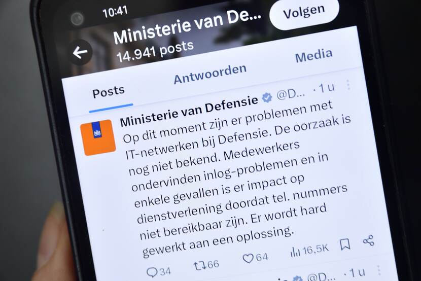 Een telefoon met daarop een Tweet (of X-je) van het ministerie van Defensie over IT-problemen